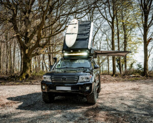 Land Cruiser with roof tent, surf board rack and awning